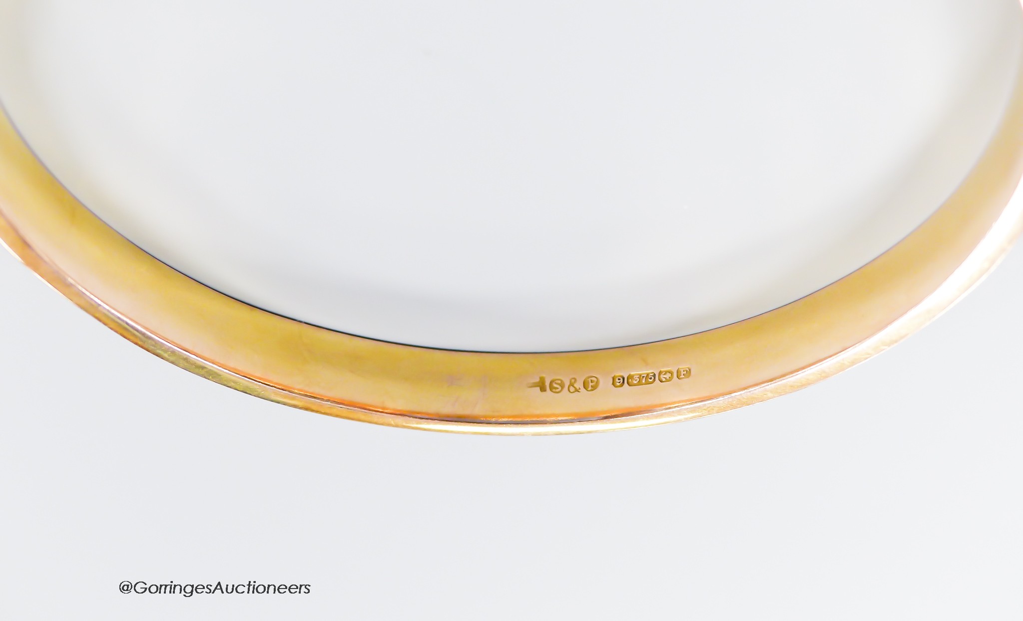 A 1930's engine turned 9ct gold bangle, interior diameter 73mm, 9 grams.